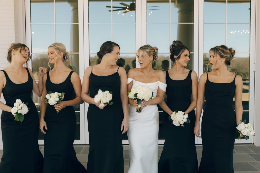 bride laughs with bridesmaids holding bouquets at The Duke Mansion Charlotte