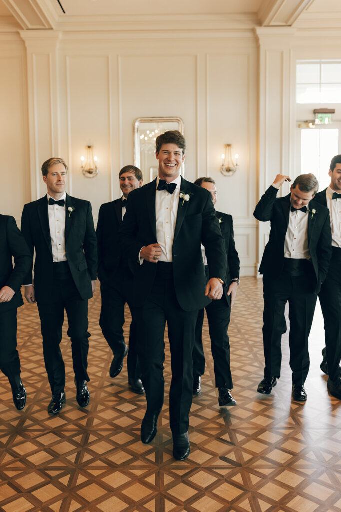 groom walks with groomsmen at The Duke Mansion Charlotte