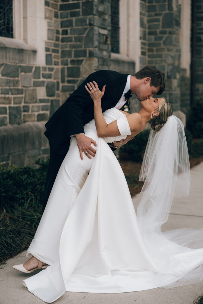 couple kisses outside of wedding church 