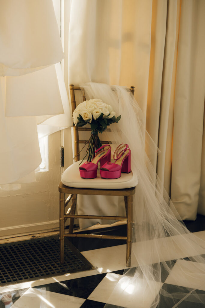 wedding shoes and bouquet beside wedding dress and veil 