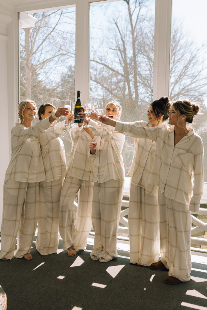 bride cheers with bridesmaids drinking champagne at The Duke Mansion Charlotte